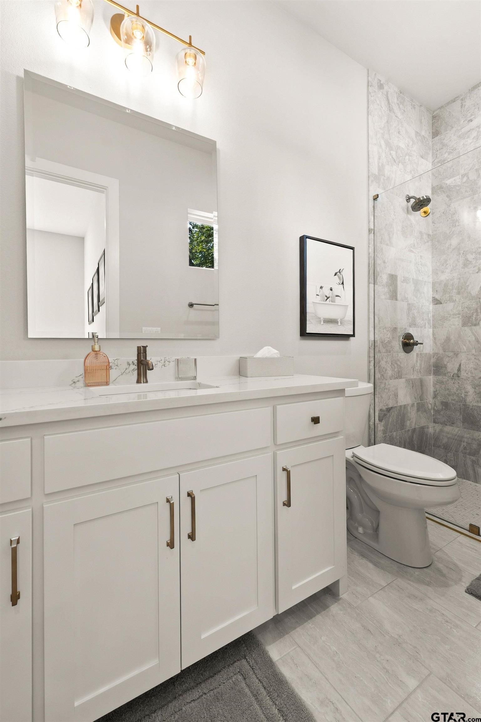 2895 Stewart Way Tyler, TX 75709 - Photo 19 of 44 a bathroom with a toilet a sink a mirror and a shower