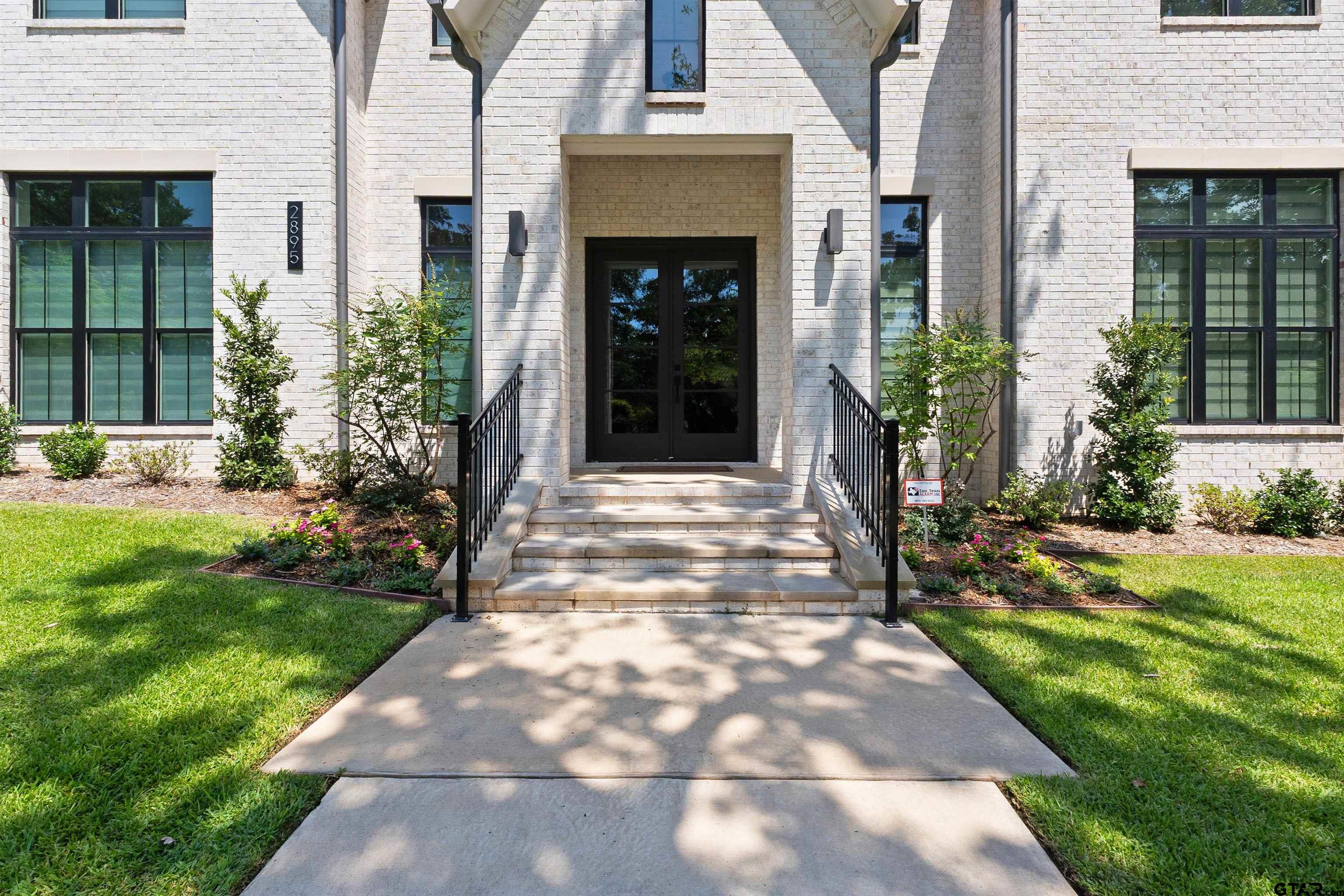 2895 Stewart Way Tyler, TX 75709 - Photo 2 of 44 a view of yellow house with a yard and plants
