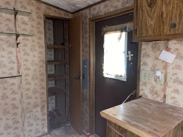 an empty room with windows and chandelier fan