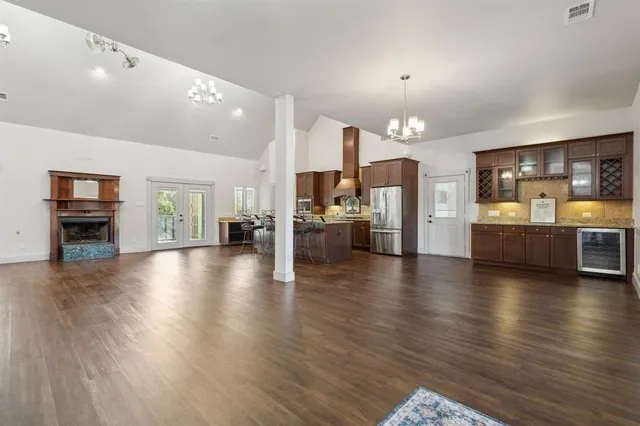 a view of a livingroom with furniture wooden floor and a kitchen
