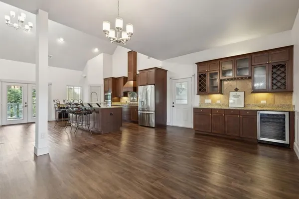 a large open kitchen with stainless steel appliances kitchen island a large counter top and a living room