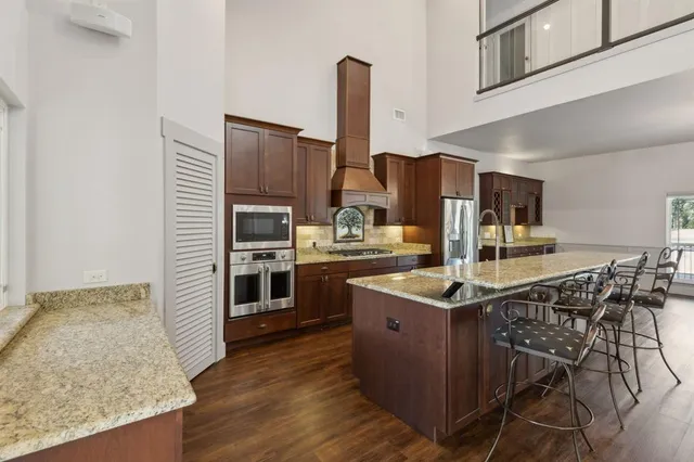 a kitchen with stainless steel appliances granite countertop a stove and more cabinets