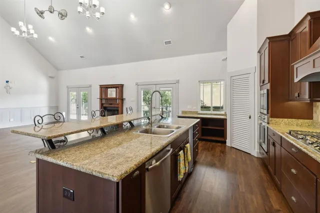 a kitchen with kitchen island granite countertop lots of counter top space and stainless steel appliances