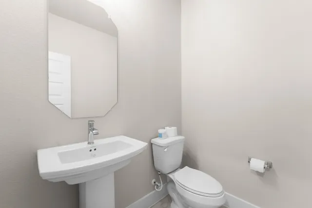a bathroom with a toilet a sink and mirror