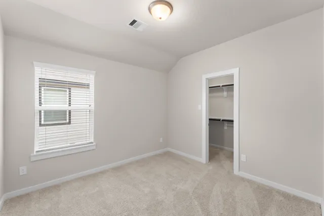 an empty room with windows and closet