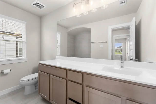 a bathroom with a sink toilet and window