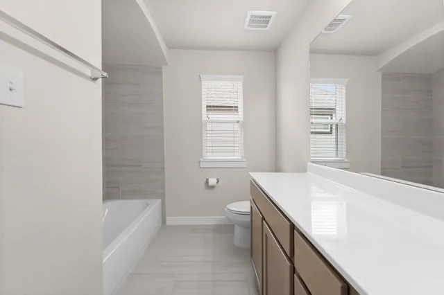a bathroom with a granite countertop sink a toilet and bathtub