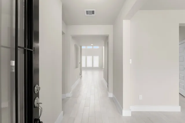 a view of a hallway with wooden floor