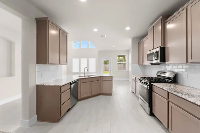 a large kitchen with stainless steel appliances lots of counter top space