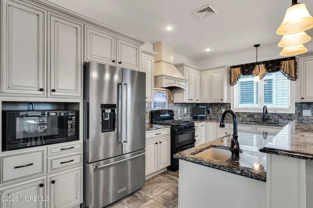 a kitchen with stainless steel appliances granite countertop a refrigerator sink and cabinets