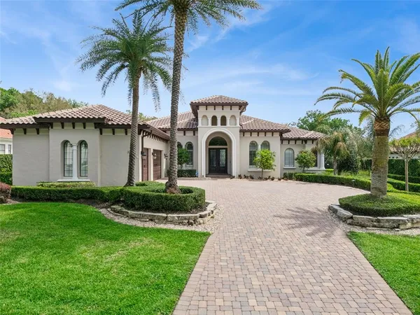 a front view of a house with a garden and palm trees