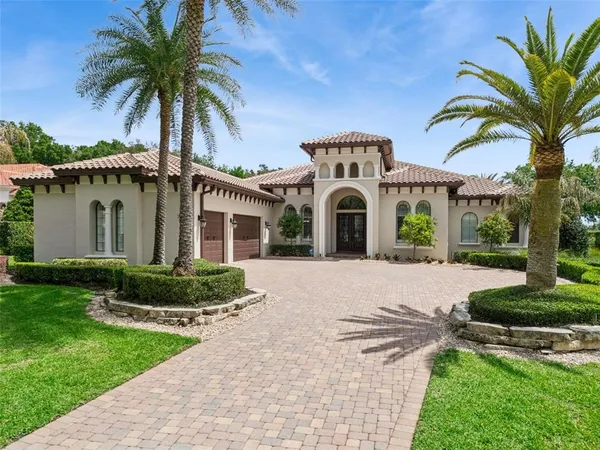 a front view of a house with garden and trees