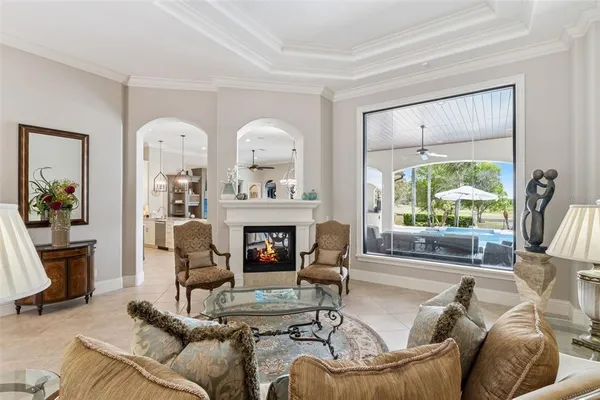 a living room with furniture a ceiling fan and a large window