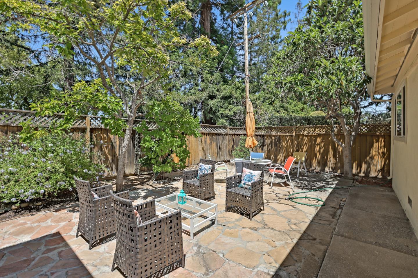 7949 Belknap Drive Cupertino, CA 95014 - Photo 8 of 8 a view of a patio with table and chairs potted plants and large tree