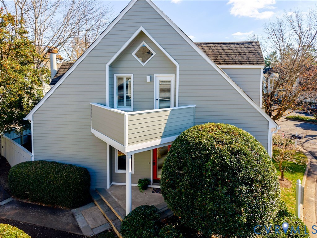 a view of a house with a small yard plants and large tree