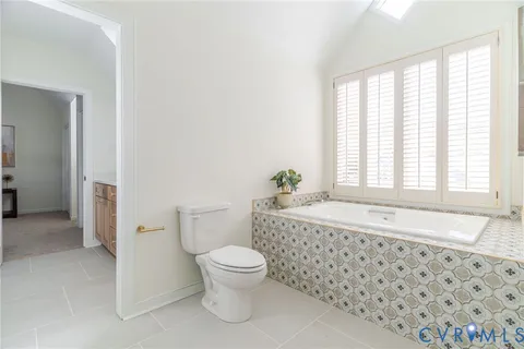 a bathroom with a granite countertop toilet a sink and a bathtub