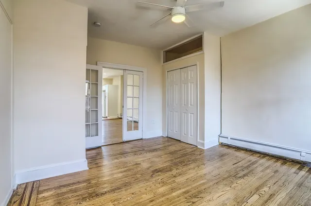 an empty room with wooden floor and windows