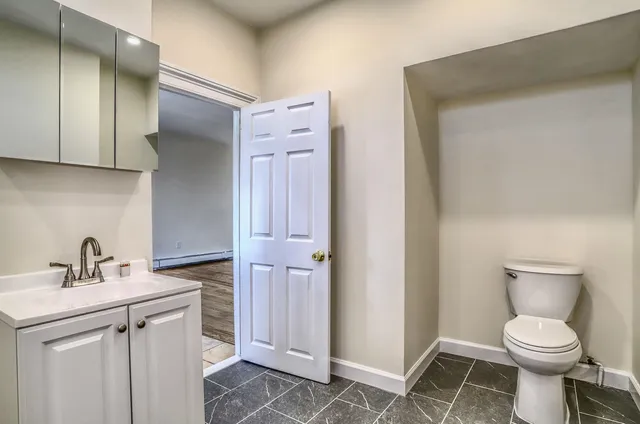 a bathroom with a toilet sink and a mirror