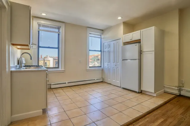 a view of a refrigerator in kitchen and wooden floor