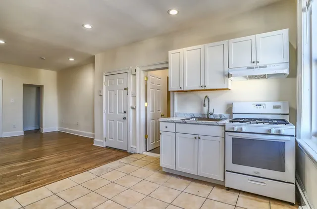 a kitchen with stainless steel appliances granite countertop a stove a sink and a refrigerator