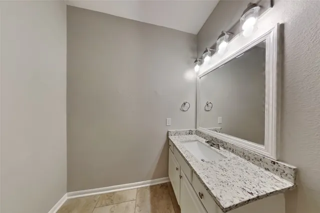 a bathroom with a granite countertop sink and a mirror