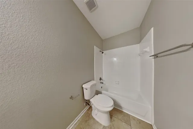 a white toilet sitting next to a bathroom sink