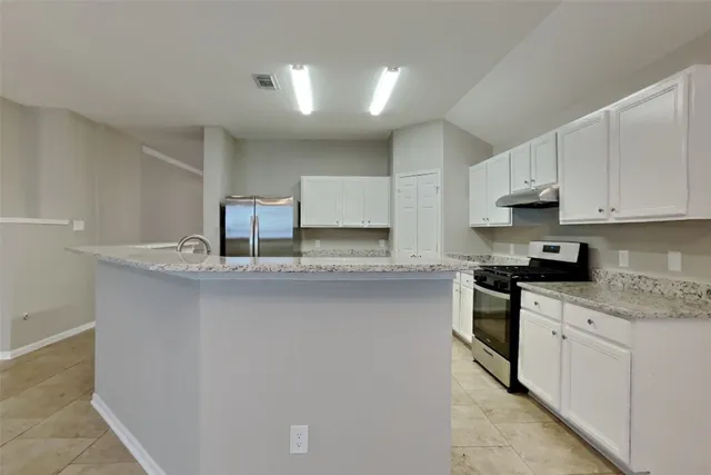 a kitchen with stainless steel appliances granite countertop a sink stove and cabinets