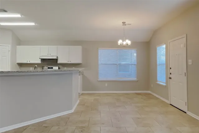 a kitchen with granite countertop a sink a stove and cabinets