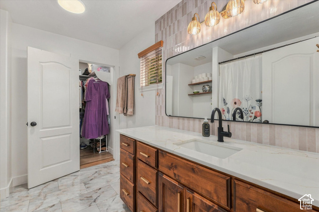 437 Scenic Heights Road Kamas, UT 84036 - Photo 21 of 46 Wood-finish vanity with gold-tone hardware, white countertop, rectangular undermount sink, and matte black faucet