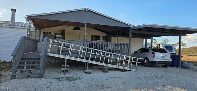 a view of house with a deck and furniture