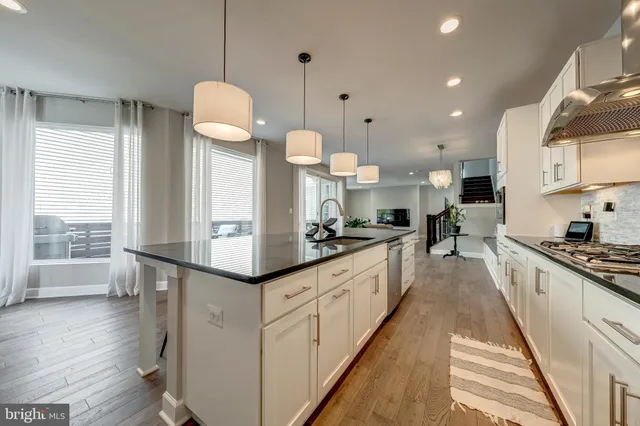 a large kitchen with lots of counter space a sink appliances and a large window