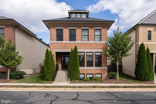 a front view of a house with a yard and potted plants