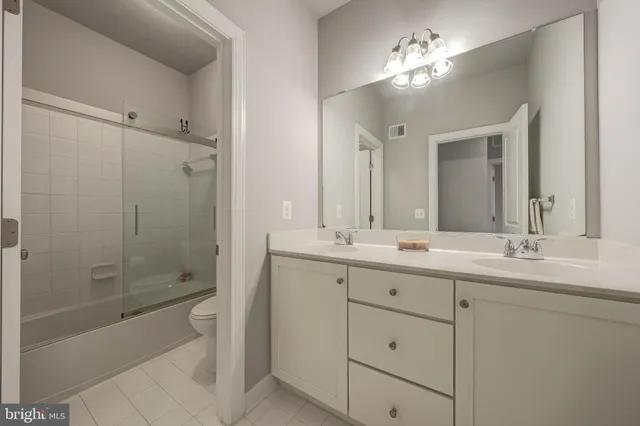 a bathroom with a double vanity sink toilet and shower