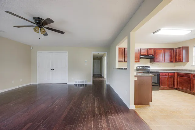 a view of a kitchen with a fridge wooden floor and a window
