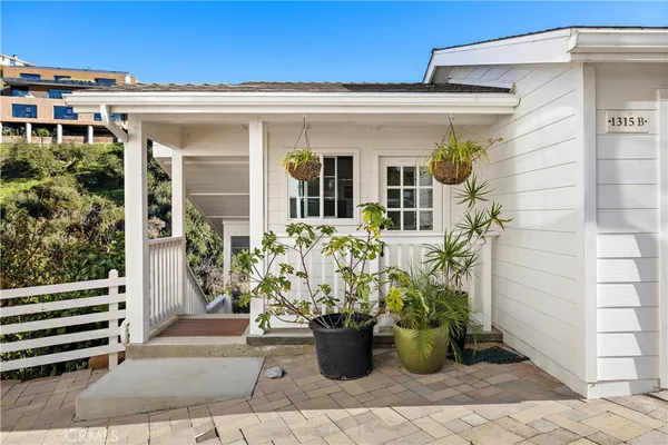 a view of a house with potted plants