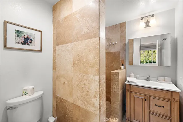 a bathroom with a granite countertop sink toilet and shower