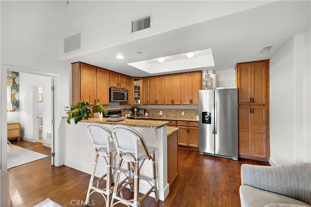 a kitchen with stainless steel appliances granite countertop a refrigerator and a stove top oven