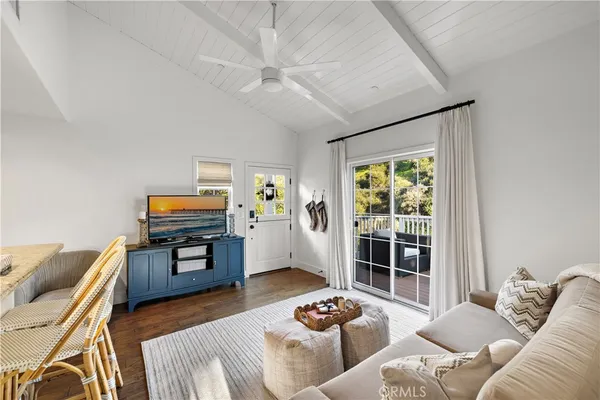 a living room with furniture and a flat screen tv with wooden floor