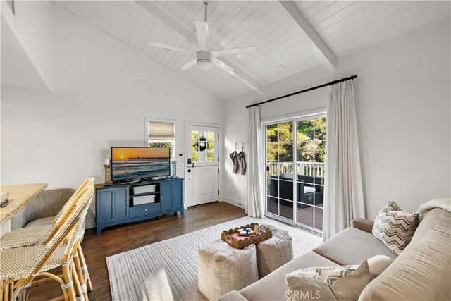 a living room with furniture and a flat screen tv with wooden floor