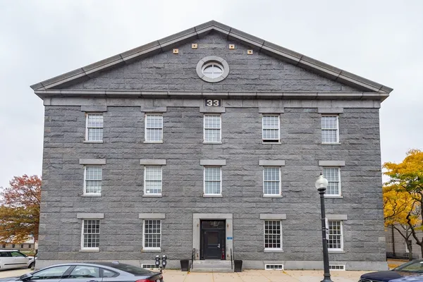 a large brick building with a clock on the wall