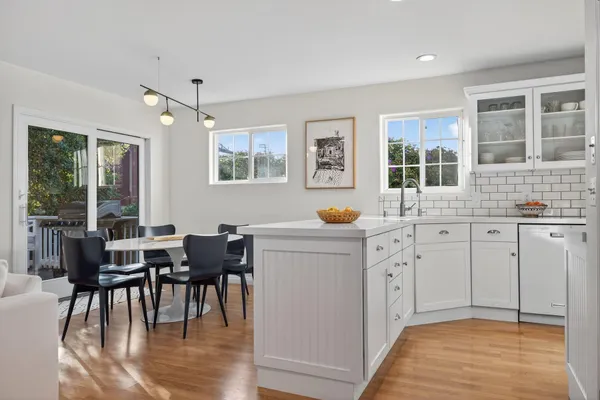 a kitchen with cabinets table and chairs