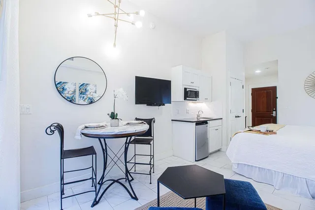 a living room with furniture a flat screen tv and a table