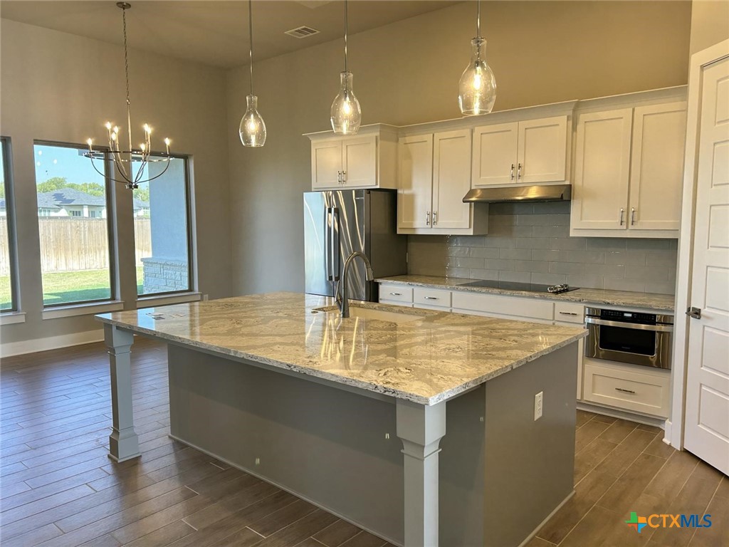6426 Clayton Court Temple, TX 76502 - Photo 7 of 34 a kitchen with kitchen island granite countertop a sink cabinets and stainless steel appliances