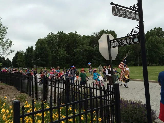 a view of a house with a small yard and large trees