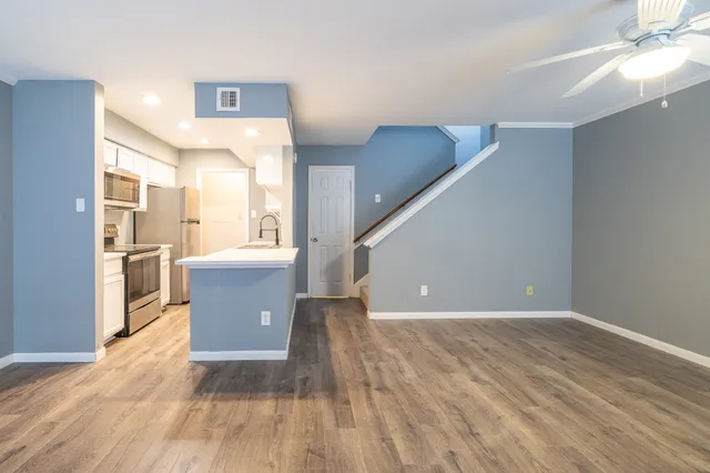 a view of a kitchen with furniture and wooden floor