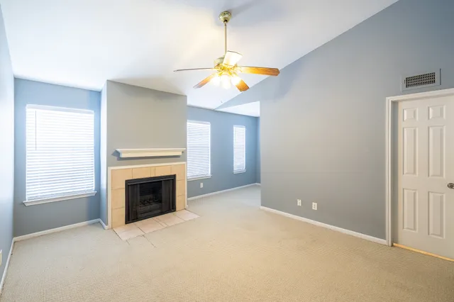 a view of empty room with fireplace and fan