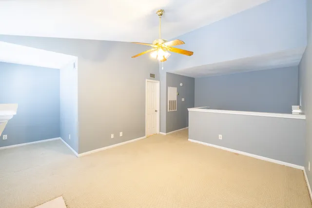 a view of an empty room with window and stairs