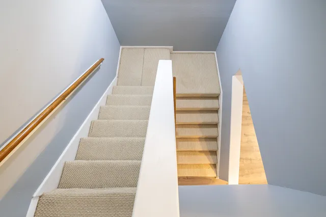a view of staircase with white walls and a window