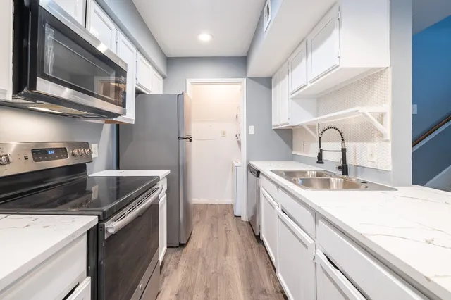 a kitchen with stainless steel appliances granite countertop a sink stove and refrigerator