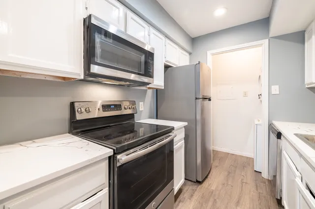 a kitchen with stainless steel appliances granite countertop a stove microwave and refrigerator